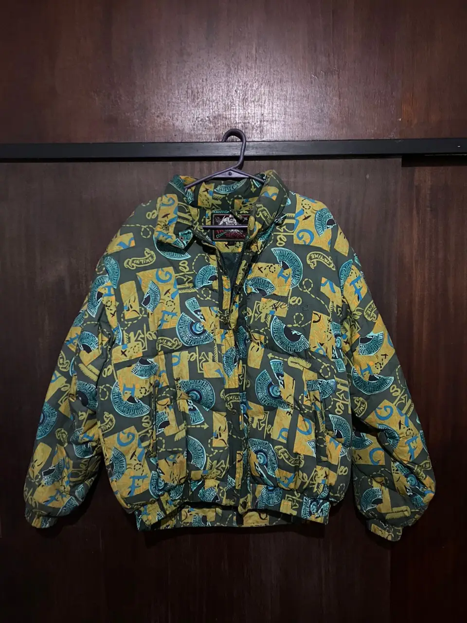 Campera de hombre con estampado retro. Diseño con motivos egipcios en tonos verde y amarillo. Ideal para un look vintage y con estilo.