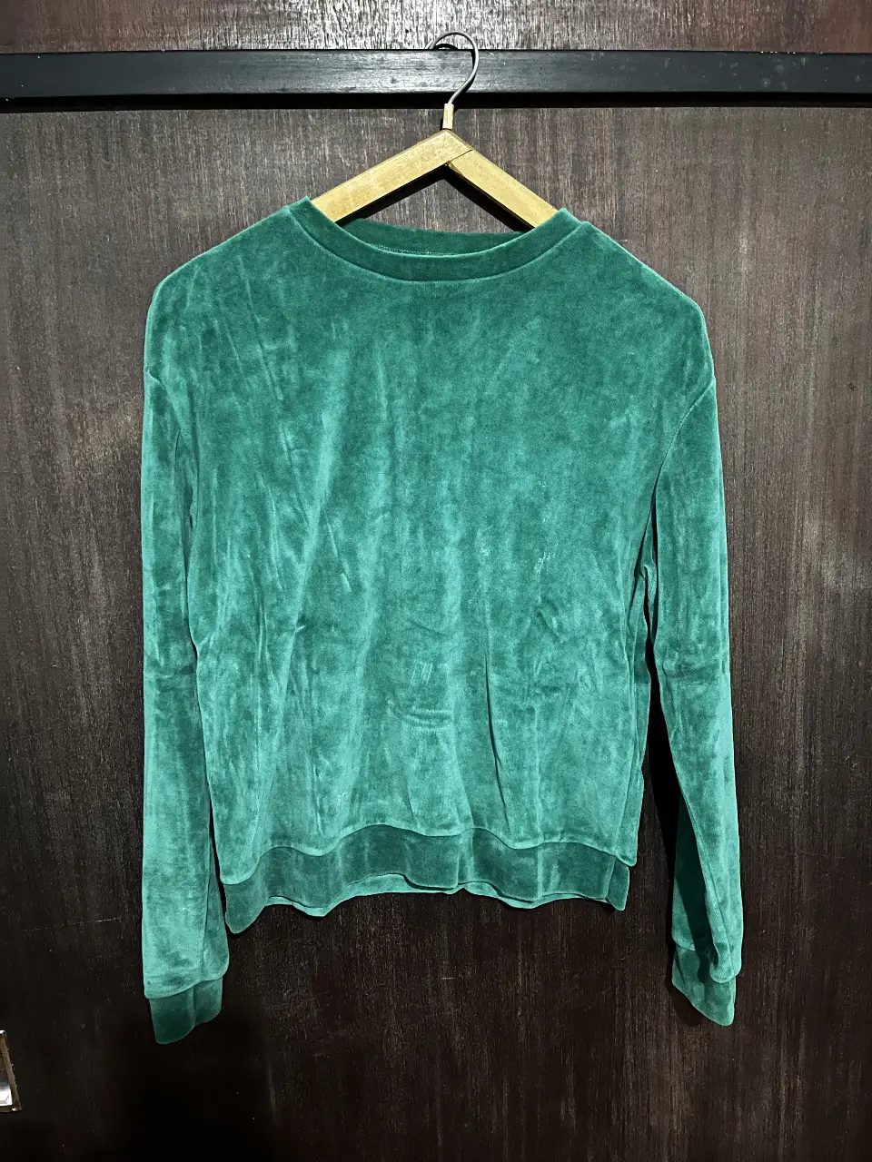 Buzo de cuello redondo de terciopelo verde, ideal para un look casual y cómodo. Perfecto para el invierno.