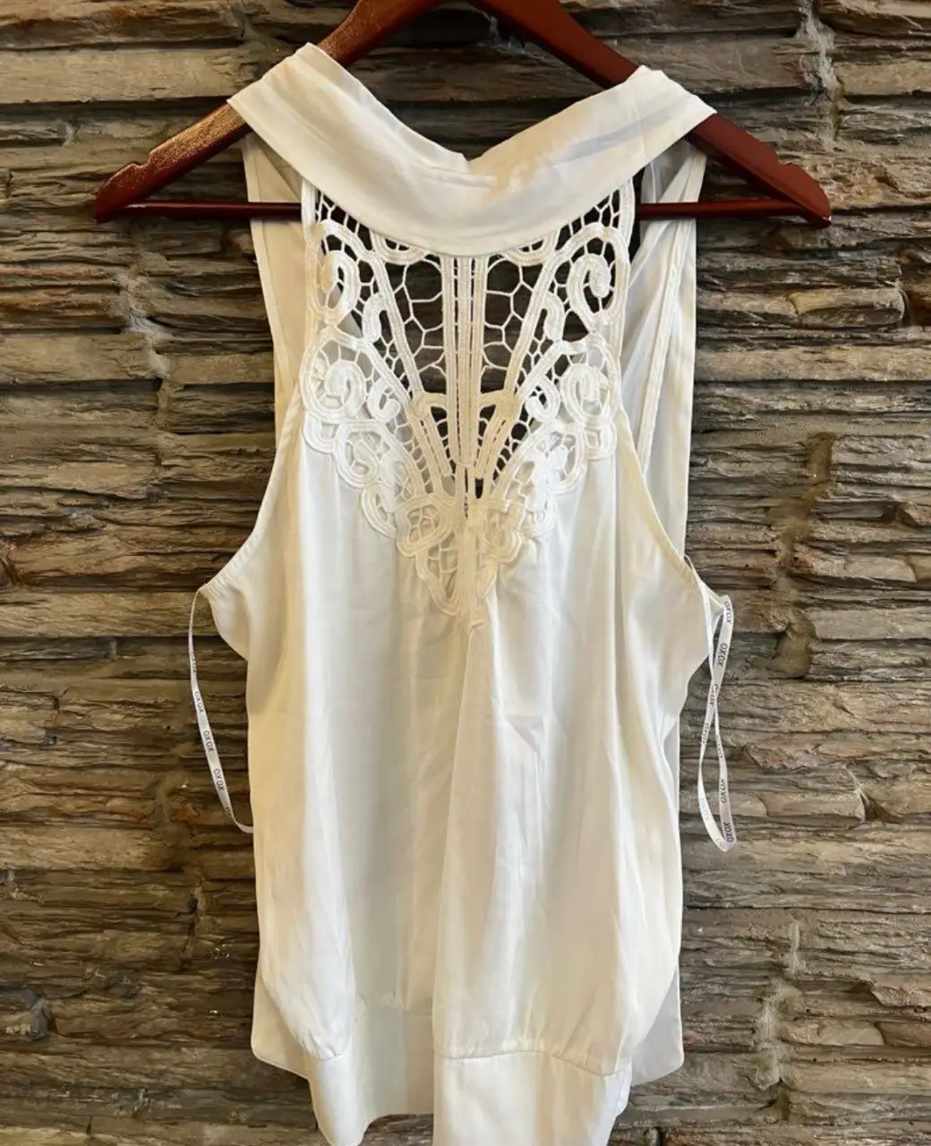 Blusa blanca con detalle de encaje en la espalda. Ideal para un look fresco y elegante.