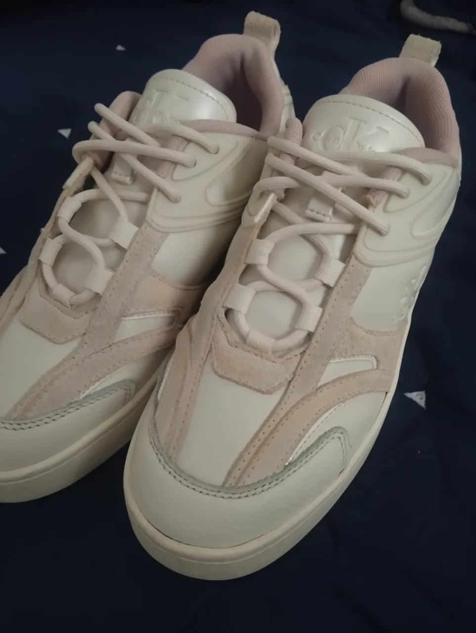 Zapatillas Calvin Klein Jeans blancas con detalles en rosa, ideales para un look casual y moderno. Con el logo de la marca en la lengüeta y la suela, estas zapatillas combinan estilo y comodidad.