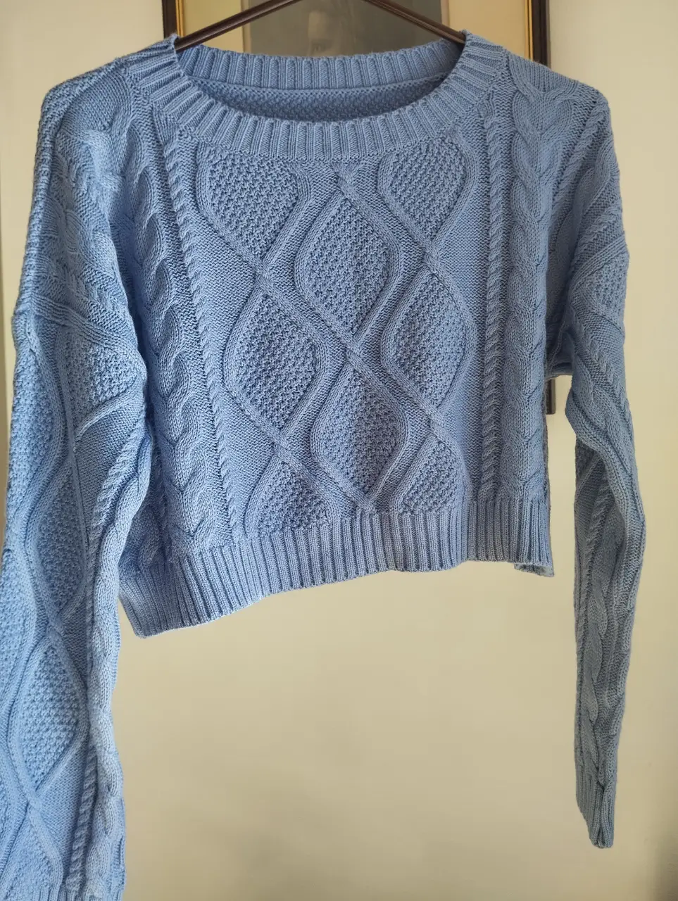 Sweater crop de punto con diseño de rombos en color celeste. Ideal para un look casual y abrigado.