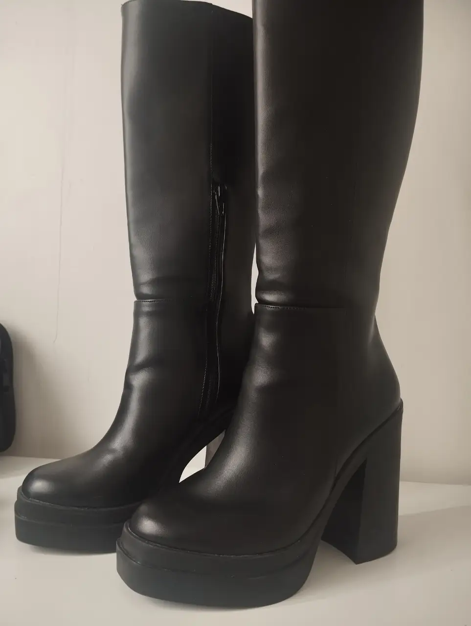 Botas de caña alta negras con plataforma y taco ancho. Ideales para un look moderno y audaz.