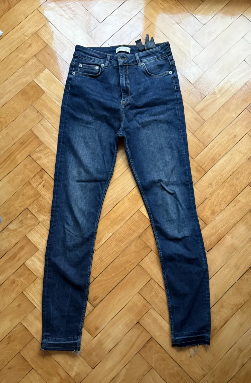 Jeans de tiro alto con detalles de desgaste en los bajos.