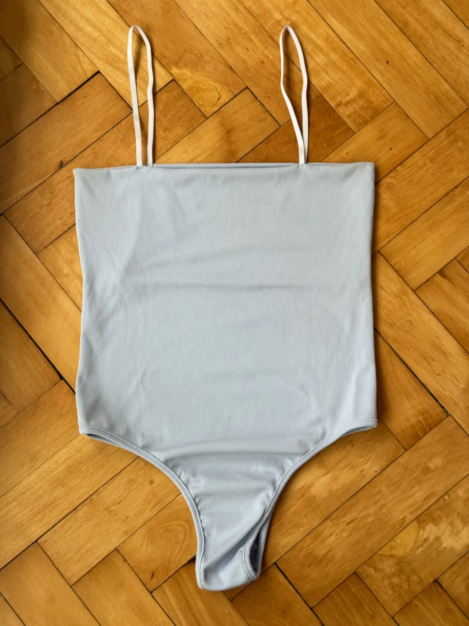 Body de morley celeste claro con tiras finas blancas. Es un body súper canchero y versátil, ideal para combinar con jeans, shorts o polleras. Su diseño moderno lo hace perfecto para cualquier ocasión.