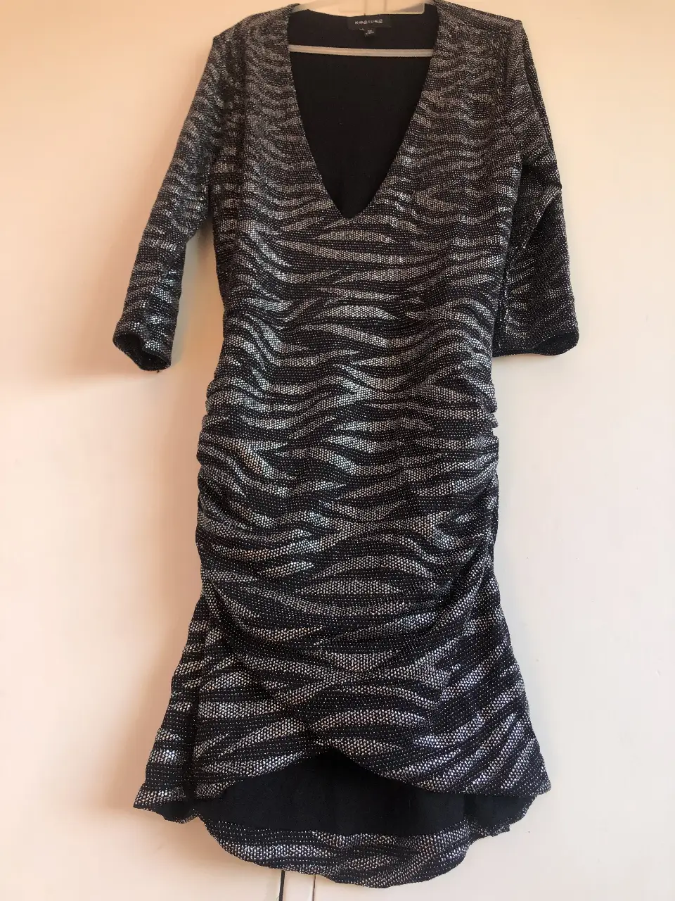 Vestido mini de fiesta con estampado de cebra en tonos plateados y negros. Diseño fruncido que estiliza la figura y escote en V. Marca Kosiuko, talle 38/XS.