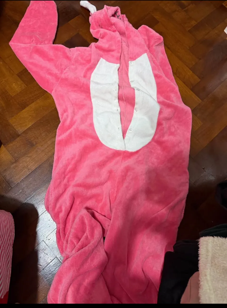pijama enterizo de conejo súper suave y calentito, ideal para estar cómodo en casa o para disfrazarse. Tiene un diseño de conejito con orejitas y carita bordada en la capucha. botones al frente y bolsillos.