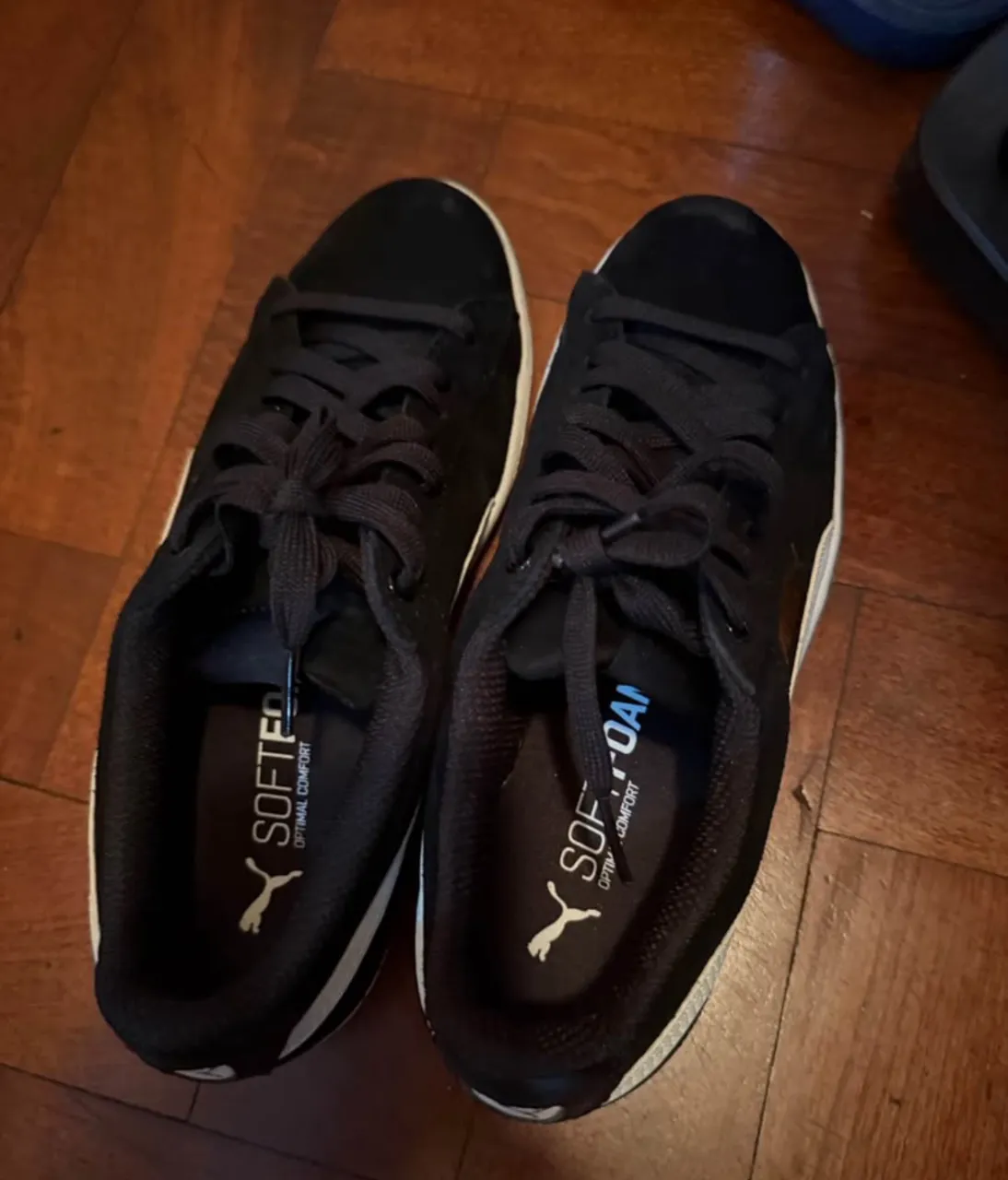 Zapatillas Puma negras con detalles blancos, ideales para el día a día. Cómodas y cancheras.