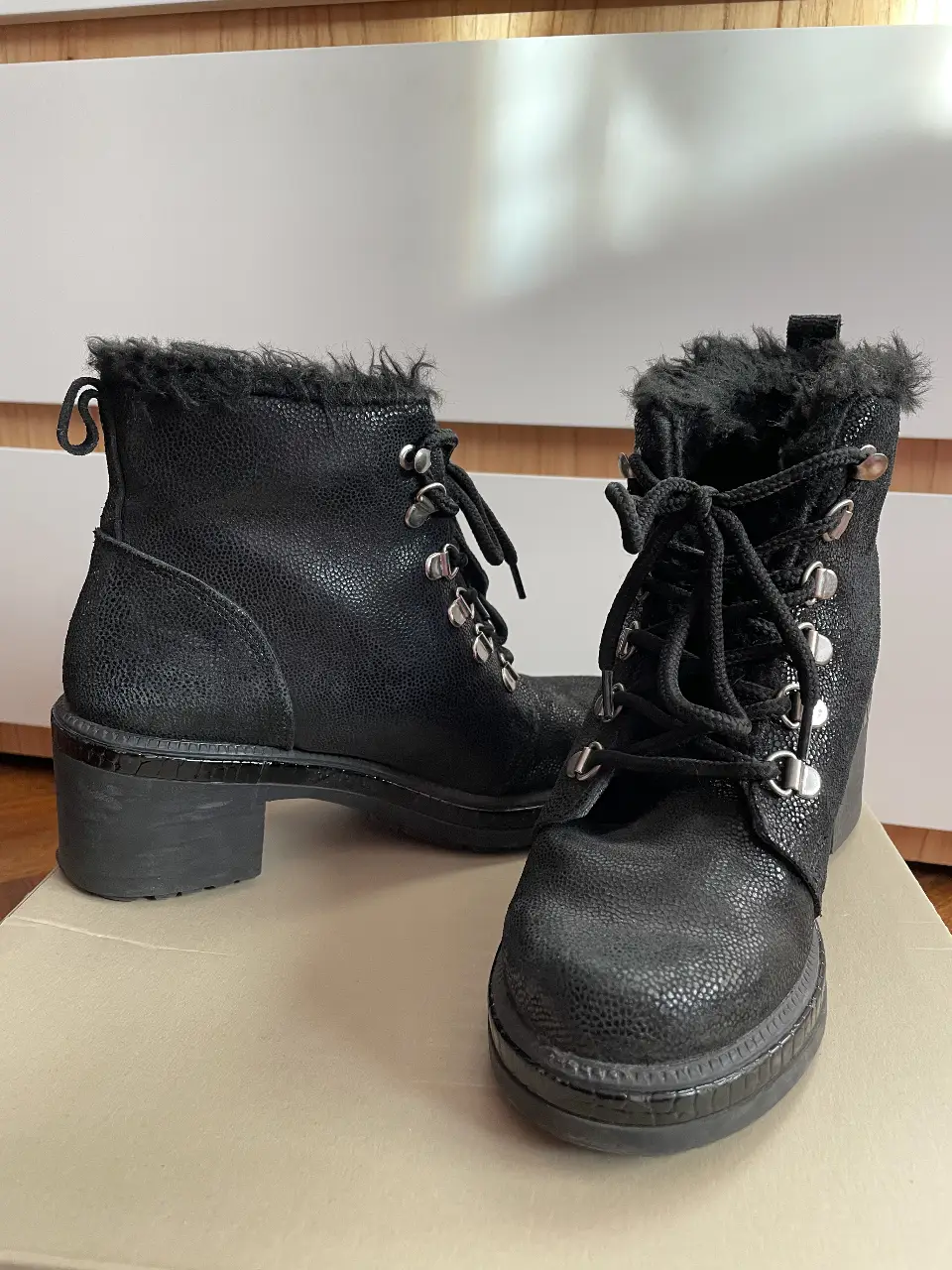 Botines negros de cuero con detalles de piel sintética en el borde superior. Cierre con cordones y detalles metálicos. Talle 36.
