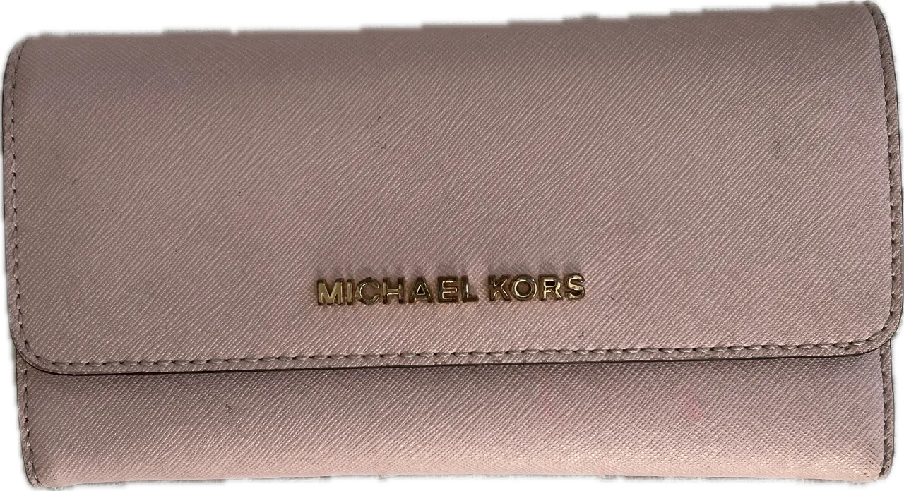 Billetera Michael Kors de cuero sintético en color rosa. Diseño con solapa y cierre a presión, con el logo de la marca en dorado. Interior con múltiples compartimentos para tarjetas y billetes.