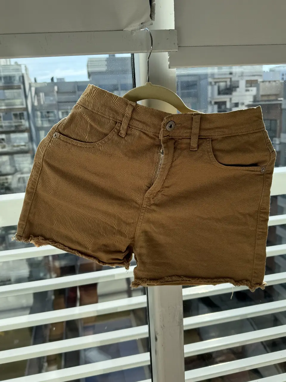 Short de jean color marrón con detalles deshilachados. Talle 24, ideal para un look casual y canchero.