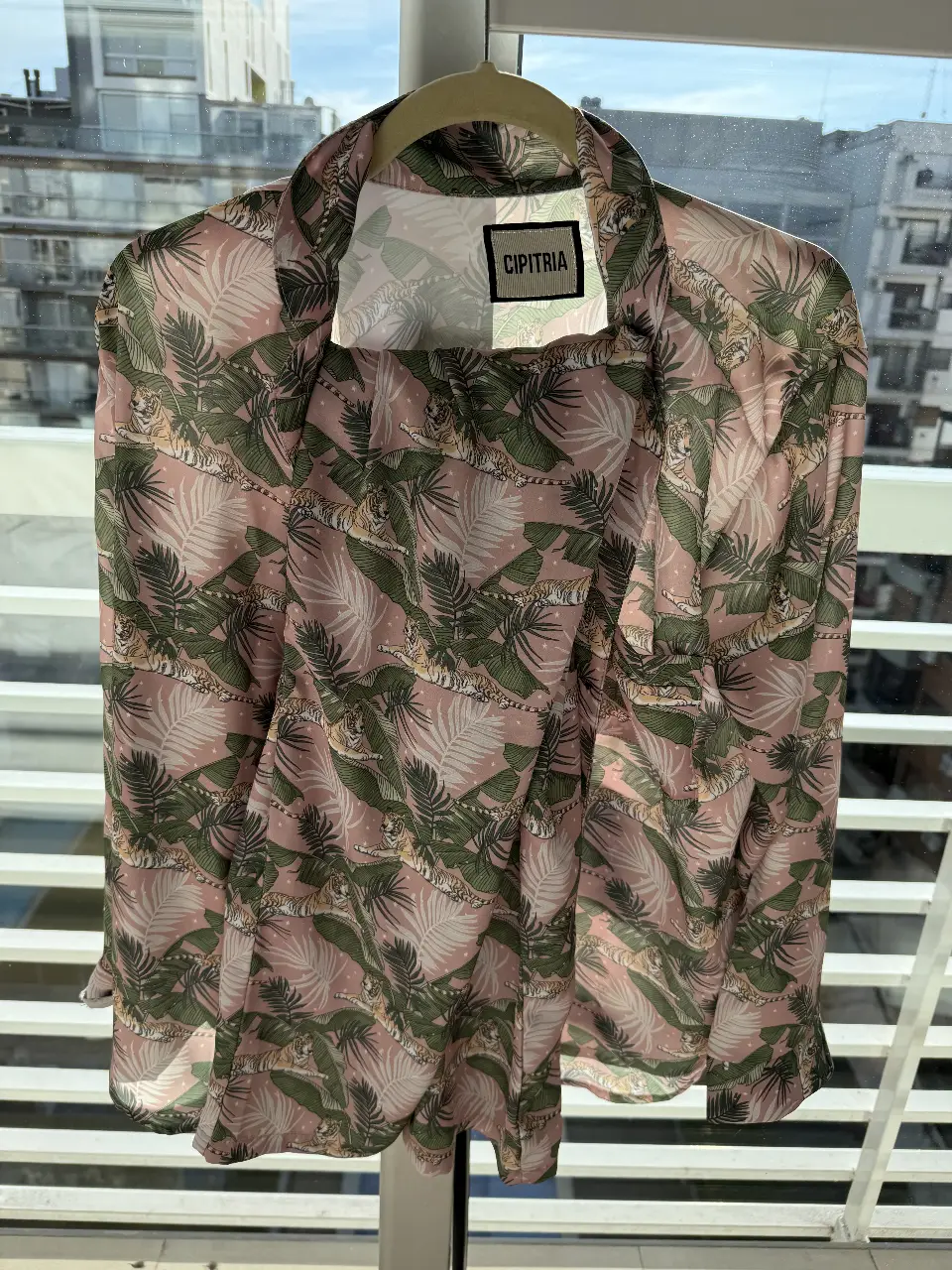 Camisa estampada con diseño de tigres y hojas en tonos rosa y verde. Ideal para un look casual y con estilo.