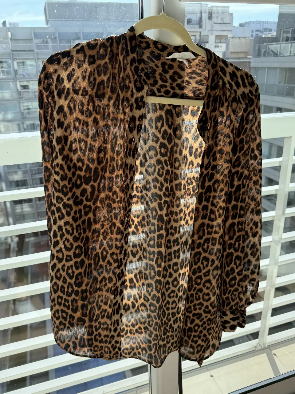 Blusa con estampado de leopardo, ideal para un look casual o de fiesta. Confeccionada en tela ligera y fluida, perfecta para combinar con jeans o pantalones de vestir. Talle S.