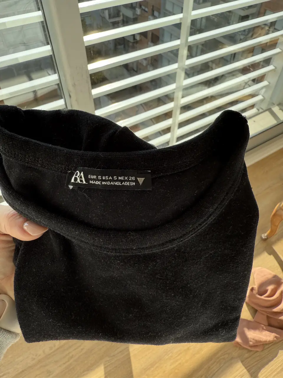 Top negro de algodón, corte ajustado y manga corta. Ideal para un look casual y versátil.