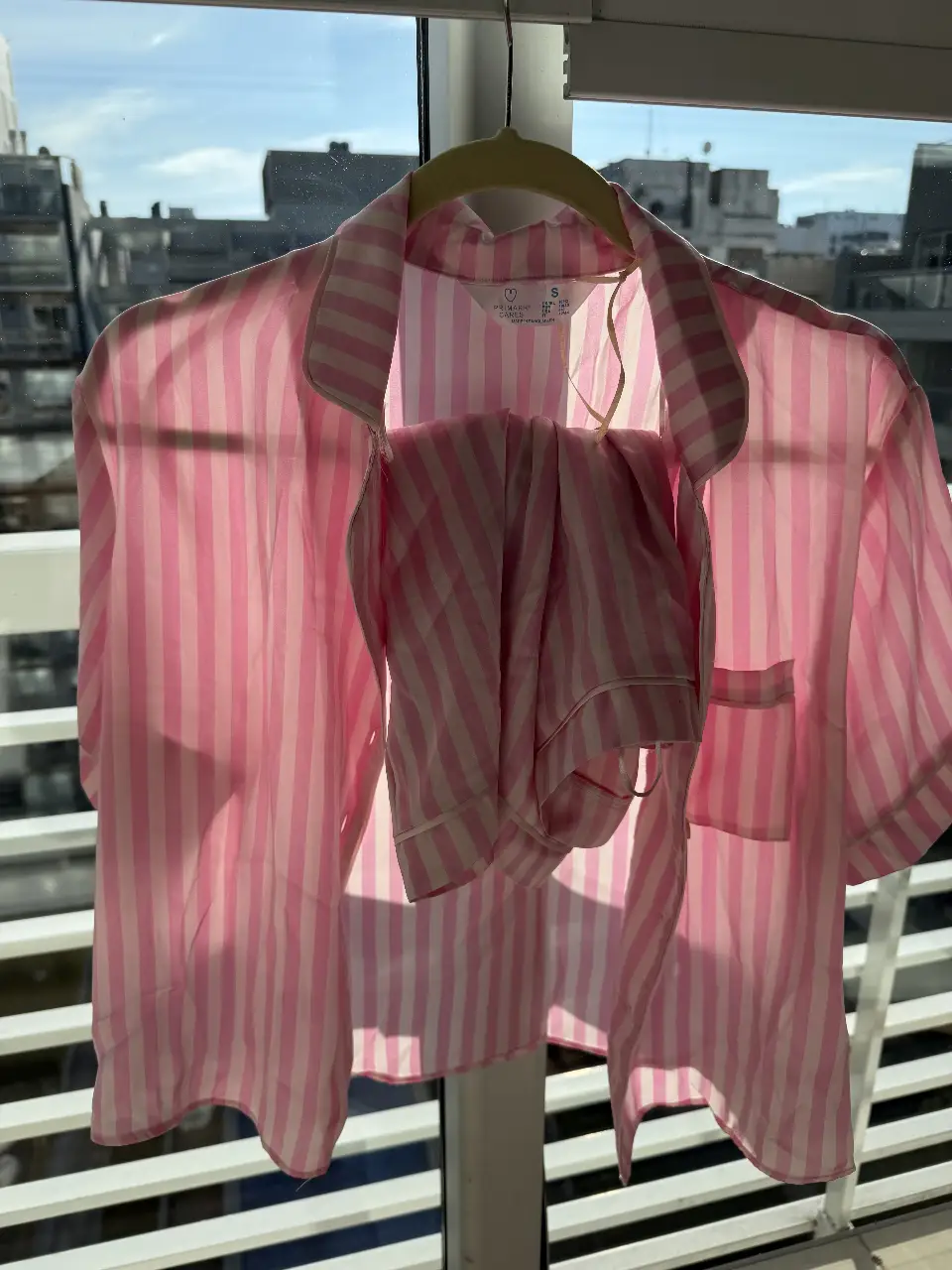 Pijama de dos piezas a rayas rosas y blancas, con camisa de manga corta y pantalón a juego. Ideal para un descanso cómodo y con estilo.