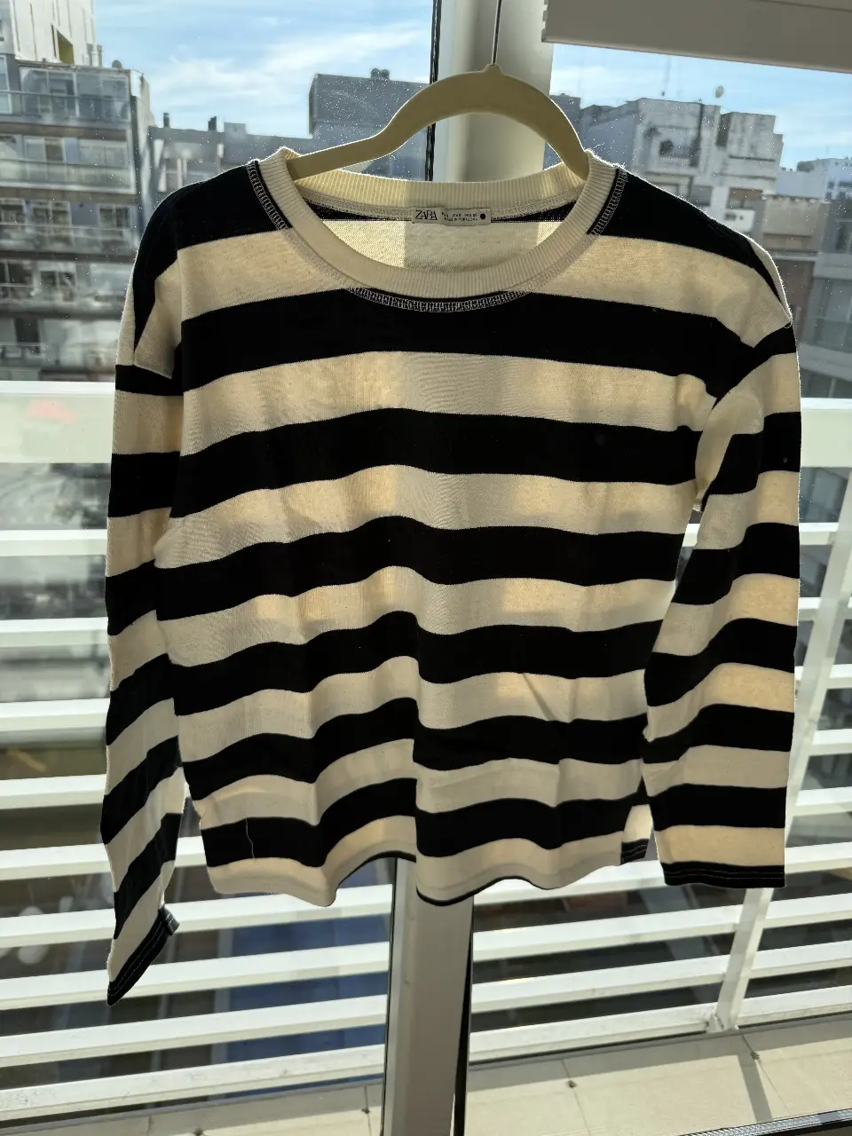 Sweater a rayas horizontales en blanco y negro, de cuello redondo. Ideal para un look casual y cómodo.