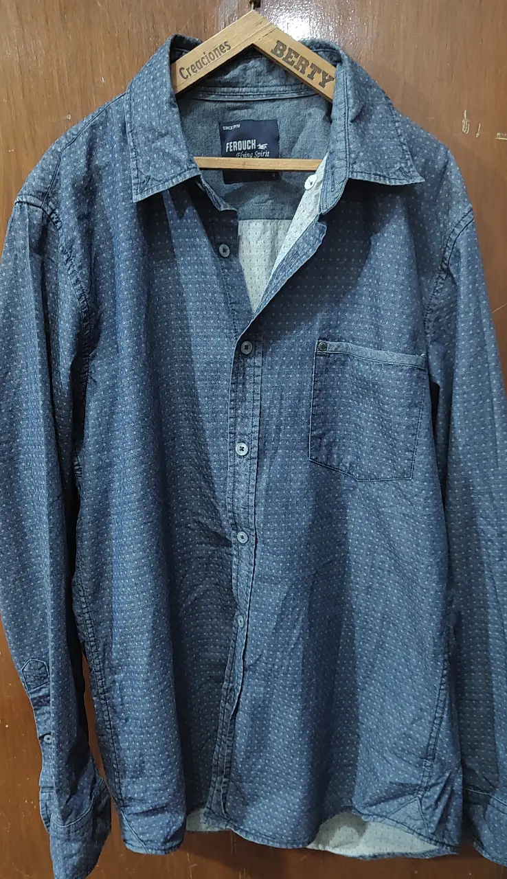 Camisa Ferouch de jean azul, manga larga, con estampado de puntos blancos. Tiene un bolsillo en el pecho y botones en los puños. Ideal para un look casual y moderno.