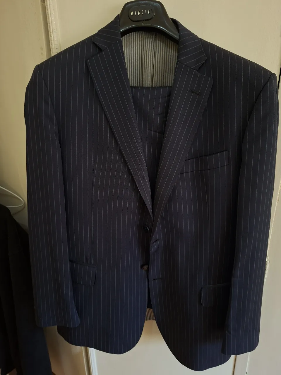 Traje de hombre azul marino a rayas, de la marca Bouzak. Incluye saco y pantalón. Ideal para eventos formales o para el trabajo.