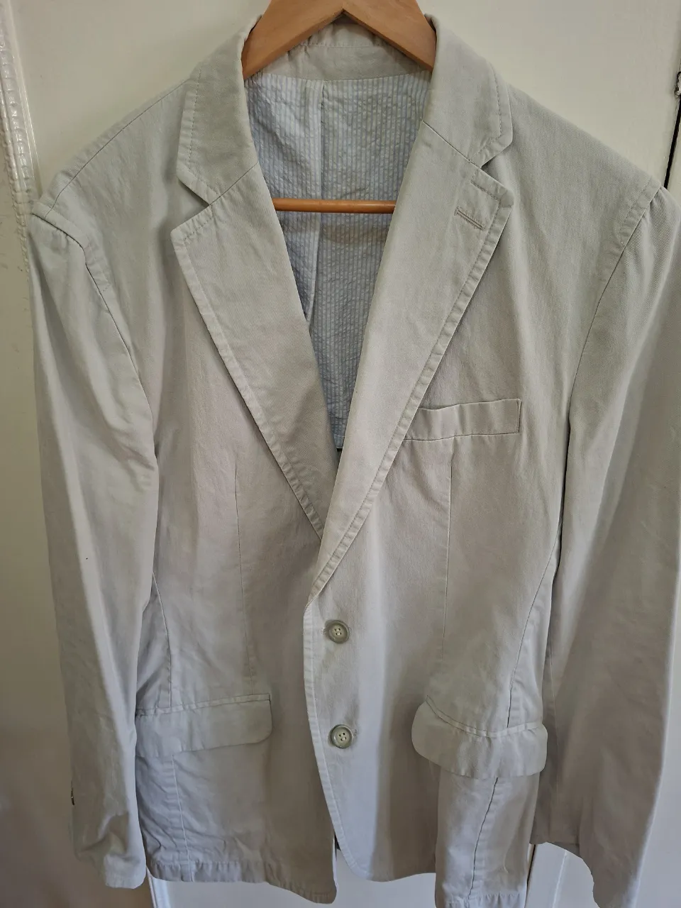 Blazer de hombre color gris claro, con dos botones y bolsillos. Ideal para un look elegante y casual.