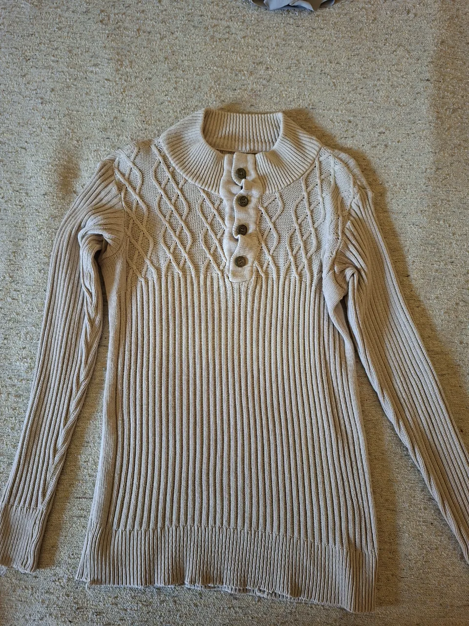 Sweater de cuello alto con botones, tejido con diseño de trenzas en el pecho. Ideal para un look casual y abrigado.