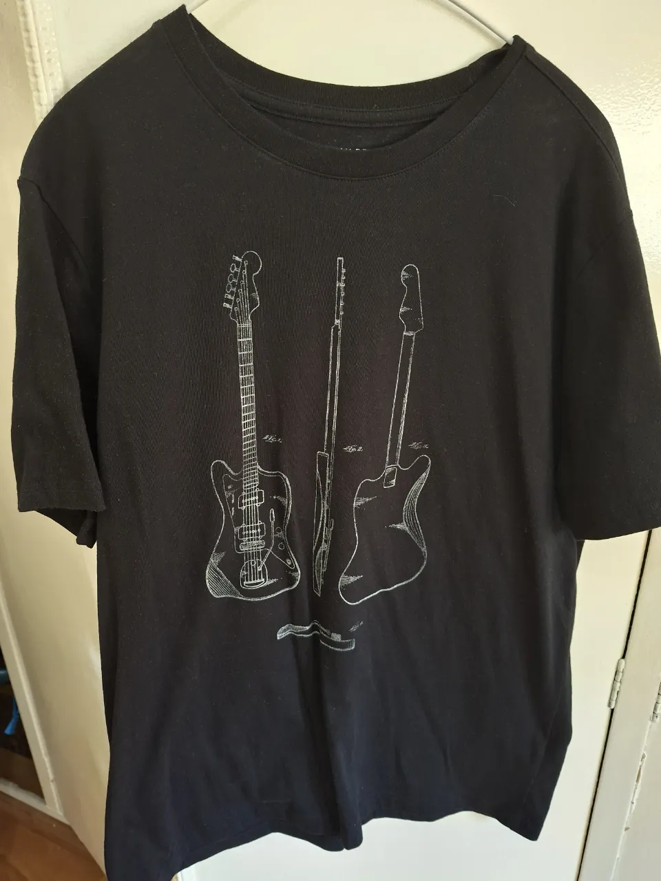 Remera negra de hombre con estampado de diseño de guitarras. Marca Banana Republic, talle L. Ideal para un look casual y moderno.