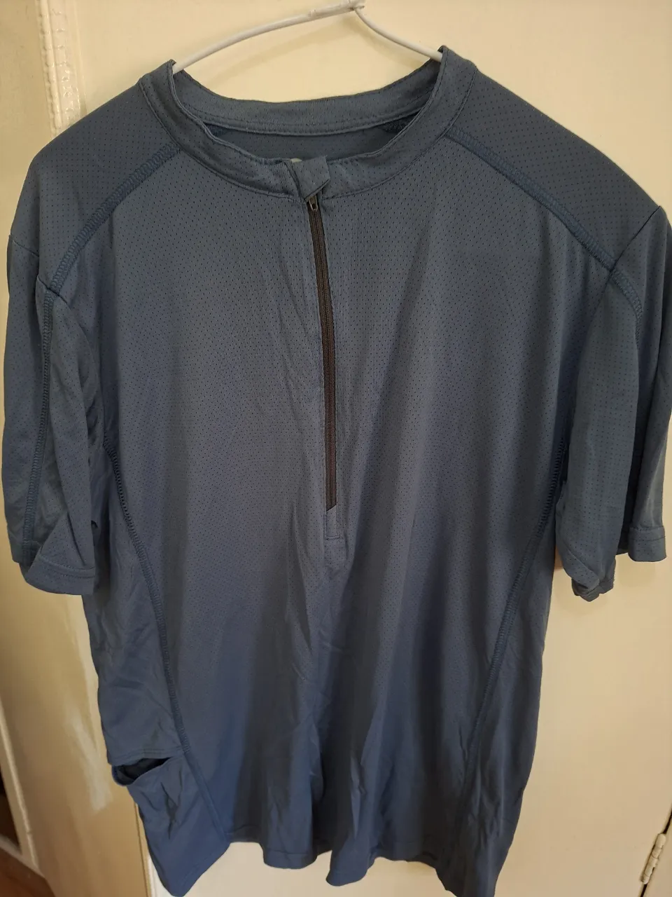 Remera deportiva de hombre, manga corta con cierre frontal. Ideal para actividades al aire libre.