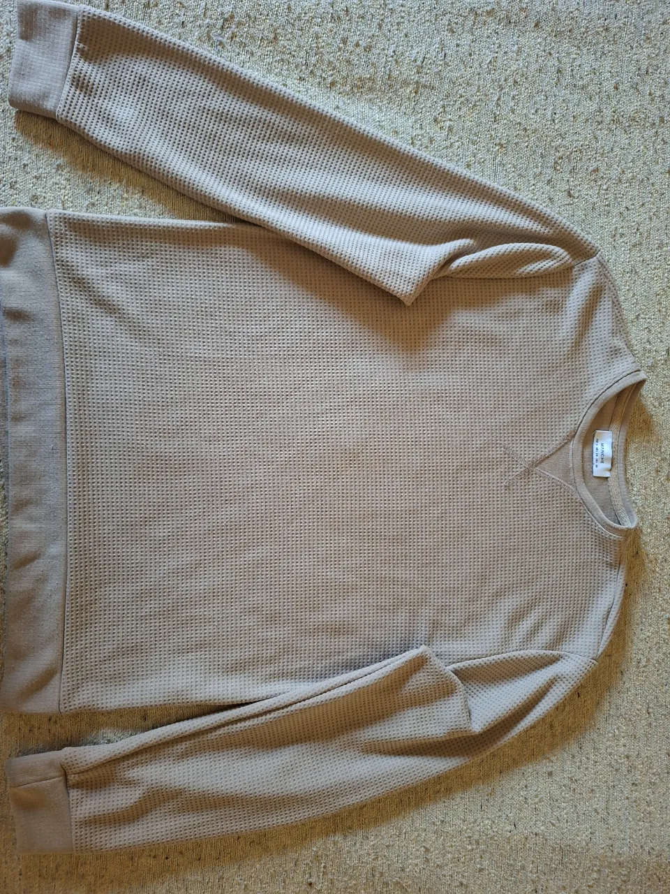 Buzo de hombre de cuello redondo, color crudo, con textura waffle. Ideal para un look casual y cómodo.