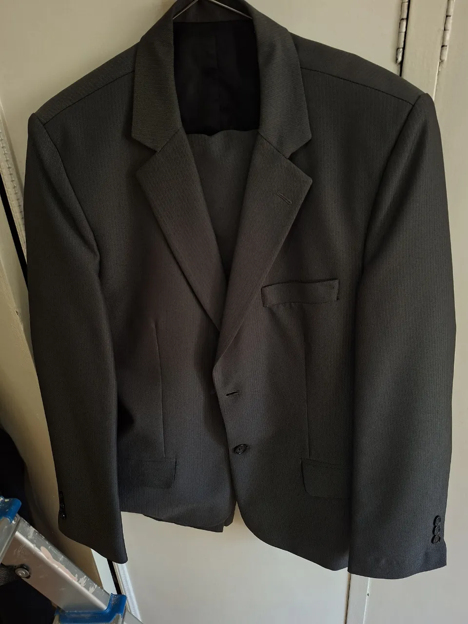 Traje de hombre gris oscuro, de dos piezas, con saco y pantalón. Ideal para eventos formales y trabajo.