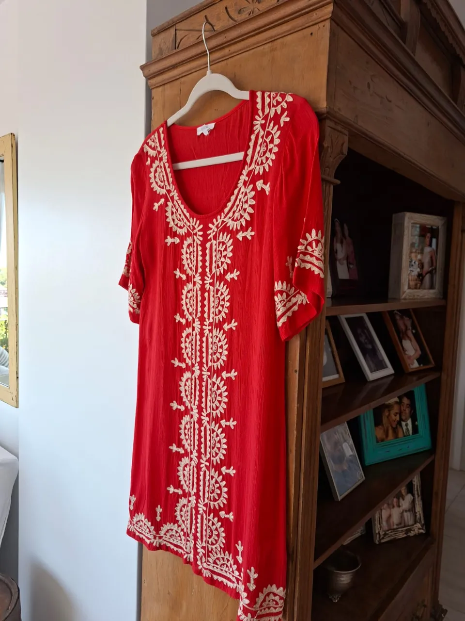 Vestido rojo con bordados blancos en el frente y mangas. Escote redondo.