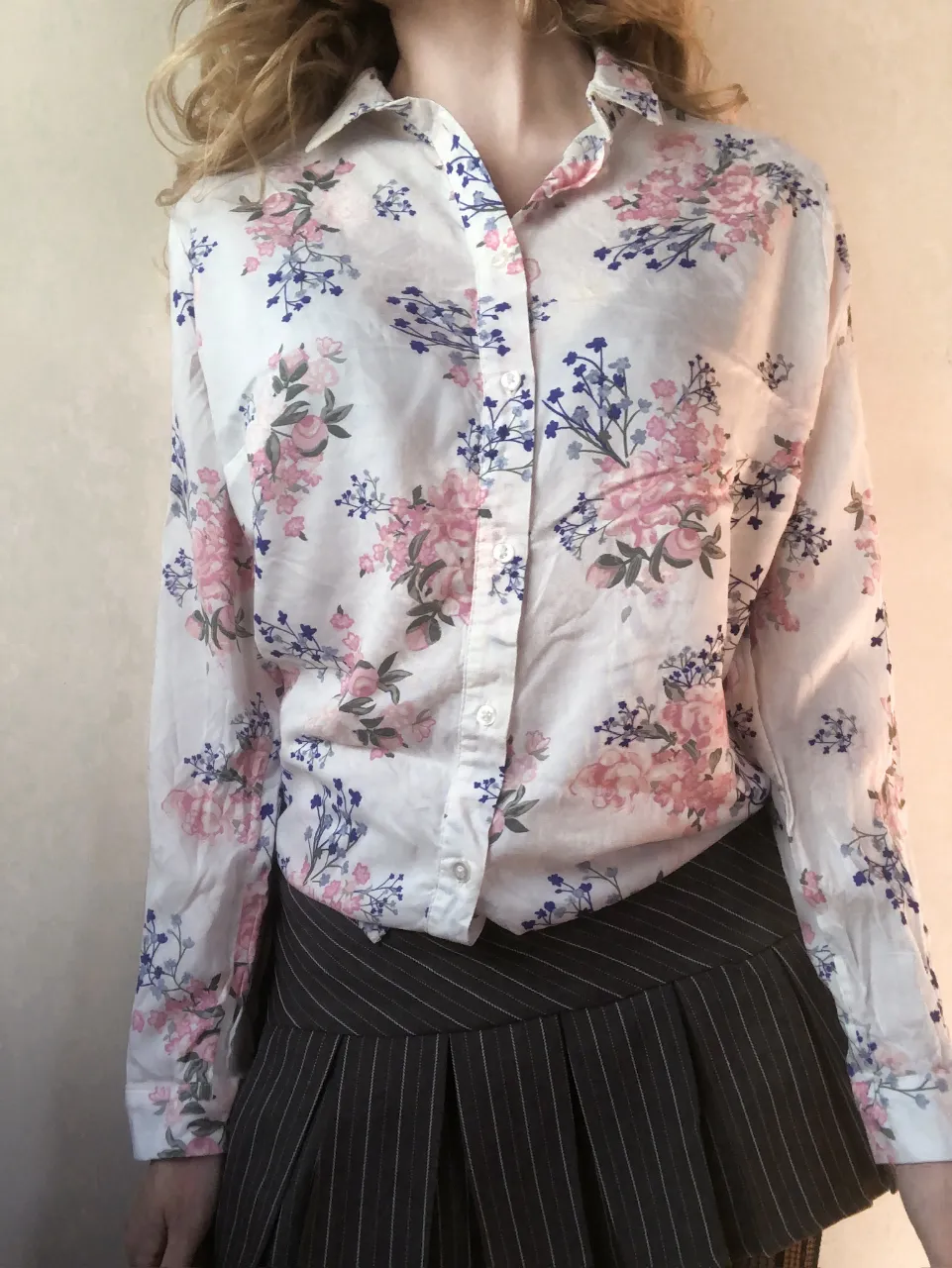 Blusa de mujer con estampado floral en tonos rosa y azul sobre fondo blanco. Manga larga y cuello camisero. Talle 40. Ideal para un look casual y femenino.