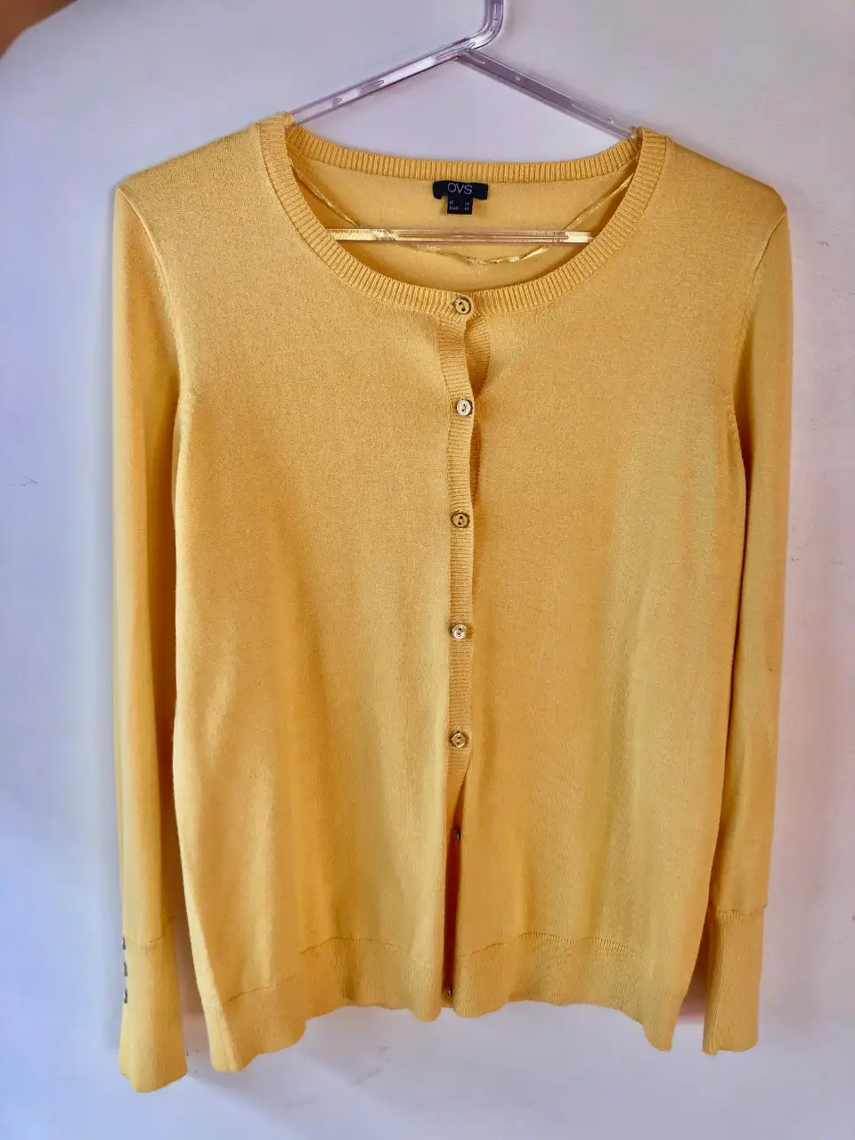 Cardigan amarillo de mujer, con botones dorados y mangas largas. Ideal para un look casual y elegante.