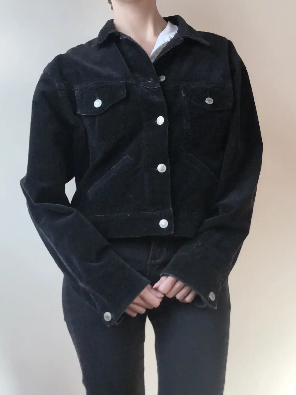 Campera de corderoy negra, estilo bomber, con botones y bolsillos. Ideal para un look casual y canchero.