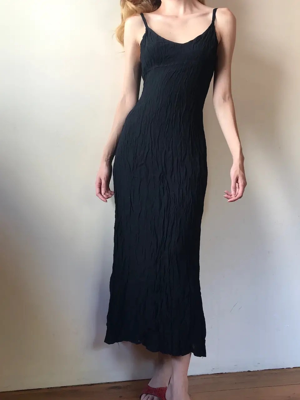 Vestido midi negro de tirantes finos, talle 2, tela fruncido y cierre en la espalda. Ideal para una salida elegante.