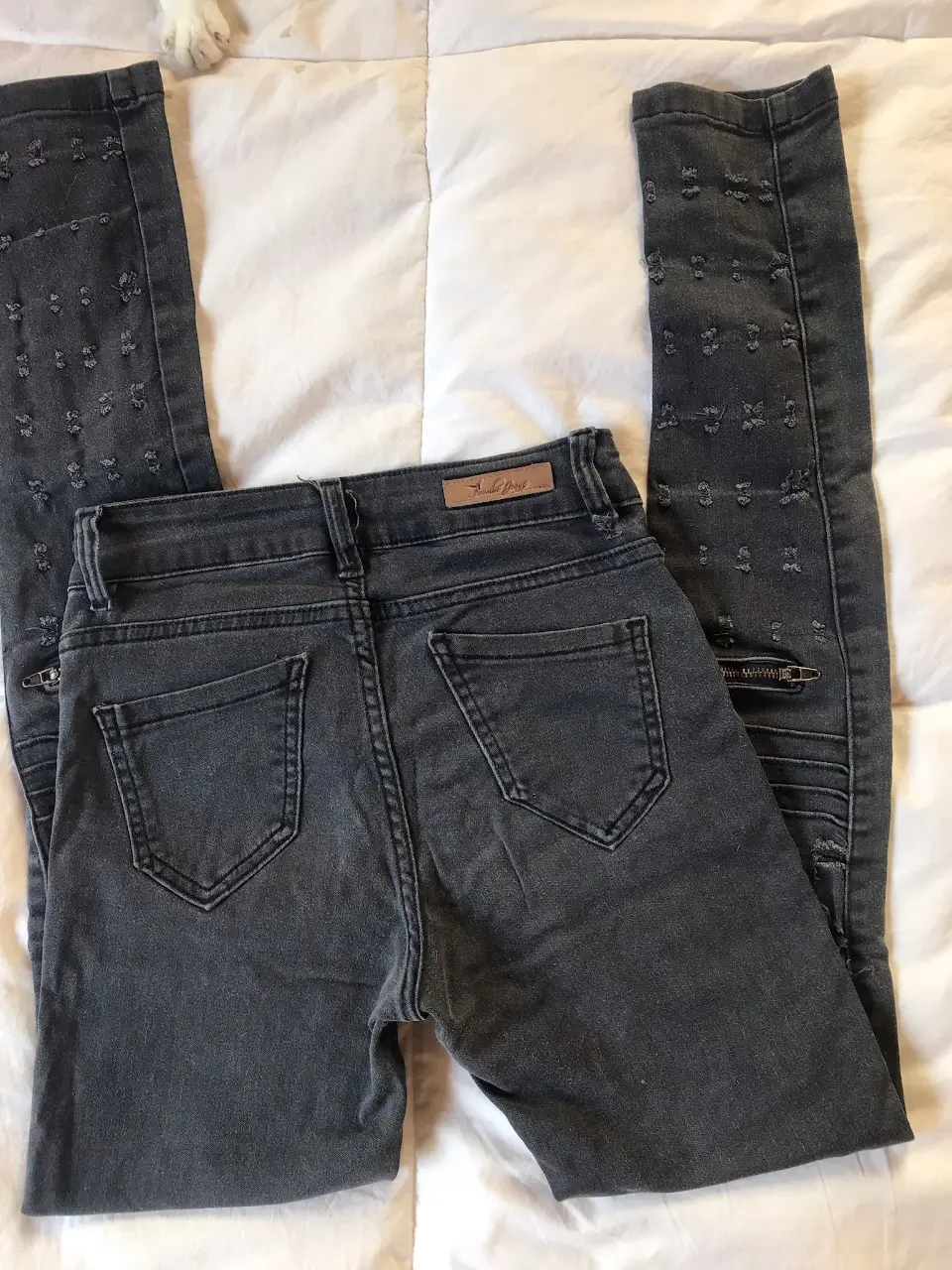 Jeans chupín, color gris oscuro, con detalles rotos y cierres en los tobillos. Talle 36 según etiqueta pero es chico, XS. Un clásico moderno para cualquier ocasión.