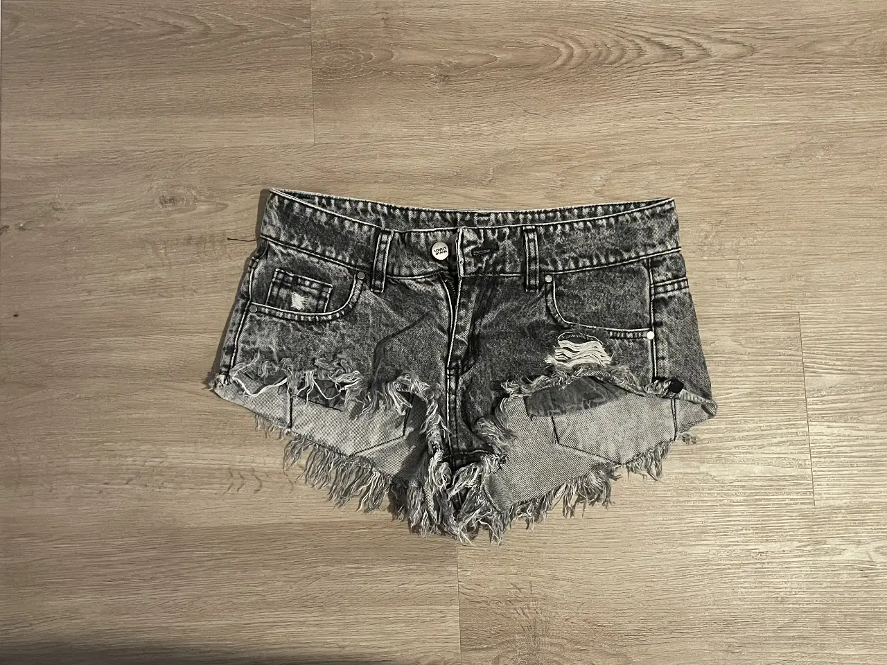 Short de jean de mujer, tiro medio, con detalles rotos y desflecado. Talle 26, de la marca Lovely Denim. Ideal para un look casual y moderno.