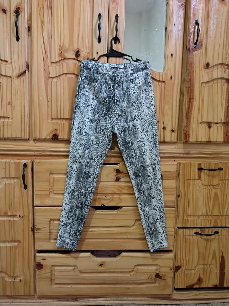 Jean tiro alto con estampa de serpiente. marca Stradivarius, elastizado, talle 28. Medidas aprox. en plano: cintura 38 cm, cadera 46 cm, tiro delantero 29 cm, tiro trasero 37 cm, largo 94 cm.