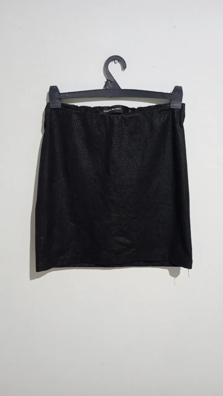 Pollera negra corta con textura de escamas. Marca Cuesta Blanca, talle M, 40. Cintura elastizada. medidas aproximadas tomadas en plano: cintura 28 cm, cadera 39 cm, largo 36 cm.