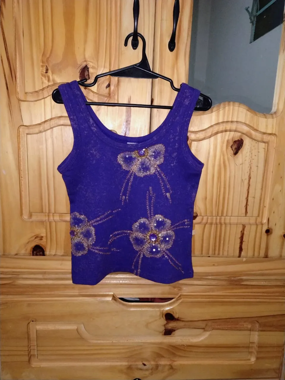 Musculosa violeta con apliques de flores bordadas y pedrería. Con detalles en lentejuelas y mostacillas, detalles en dorado y brillo. medidas aproximadas tomadas en plano: sisa 33 cm, largo 47 cm. Elastizada