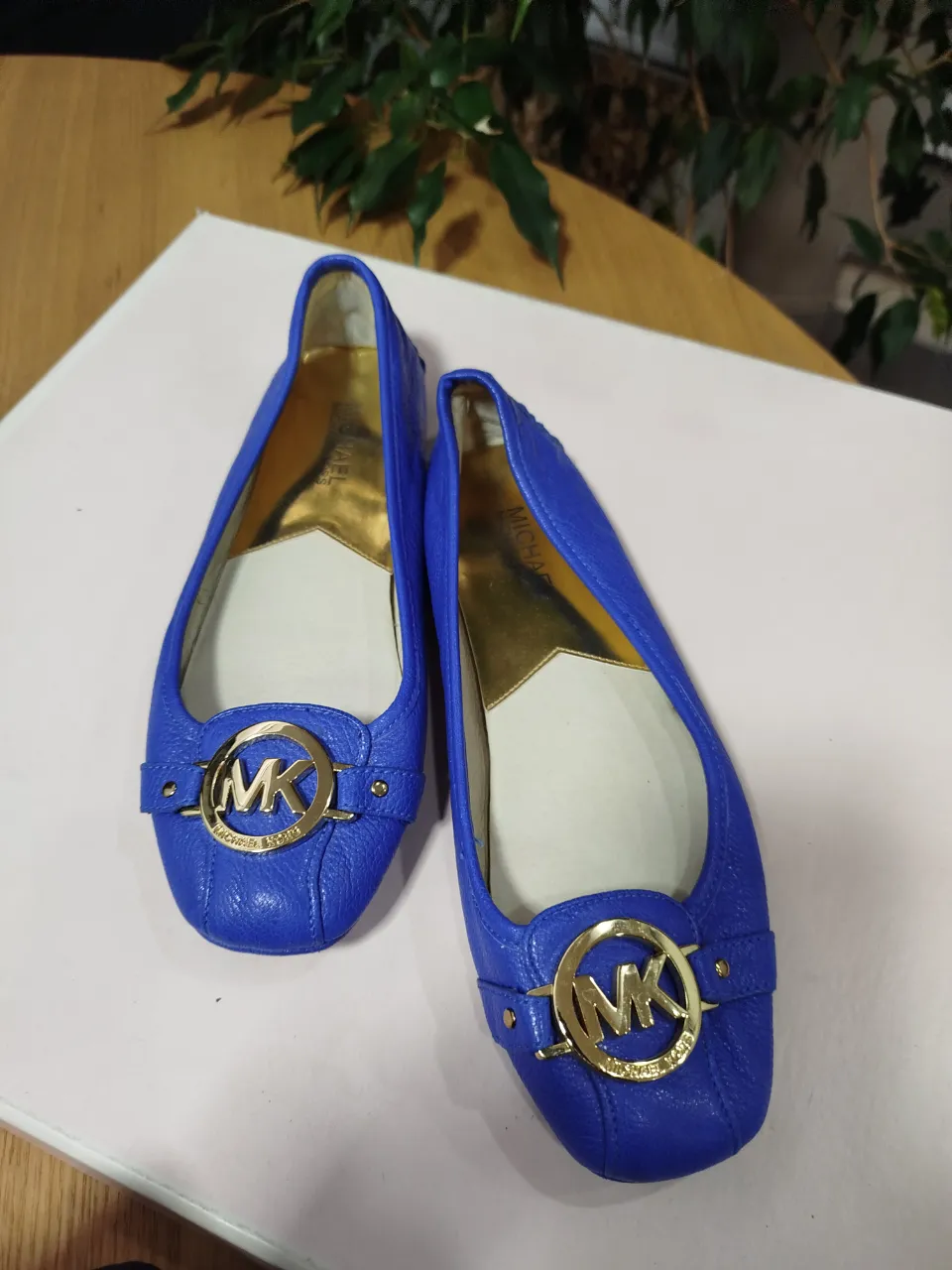 Ballerinas azules de cuero con detalle dorado y logo de la marca. Ideales para un look casual y elegante.
