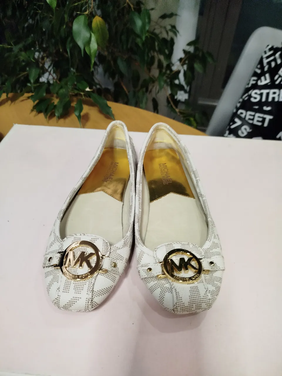 Ballerinas Michael Kors blancas con estampado del logo MK y detalles dorados. Ideales para un look casual y elegante.