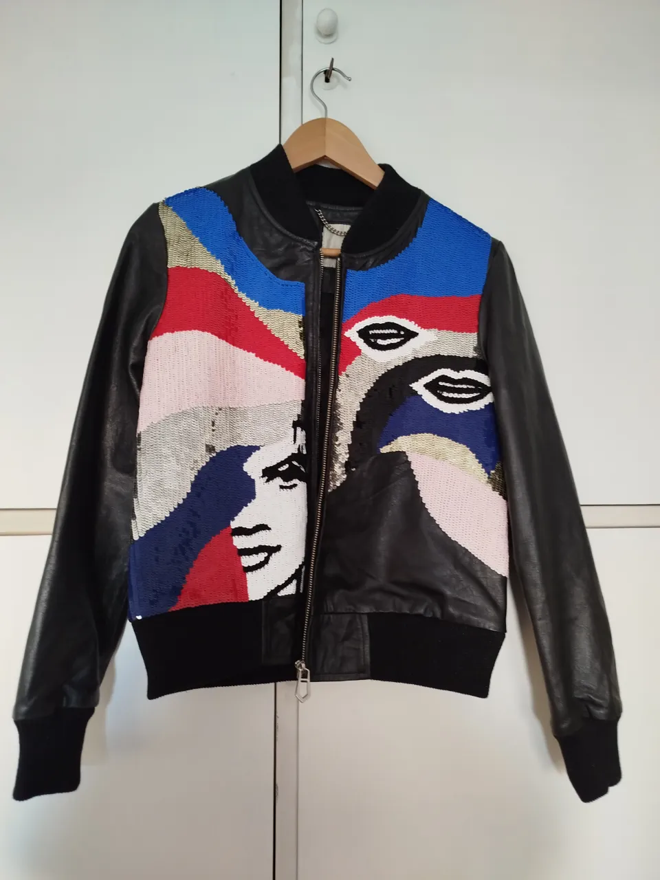 Campera de cuero negro con detalles de lentejuelas multicolores en el frente y espalda. Ideal para un look moderno y llamativo.