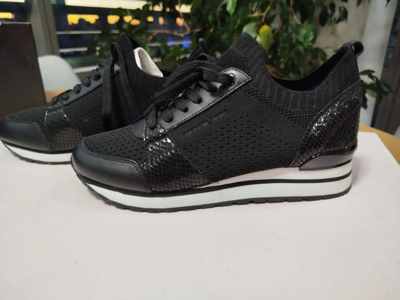 Zapatillas Michael Kors negras de mujer, con detalles en charol y diseño moderno. Ideales para un look casual y cómodo.