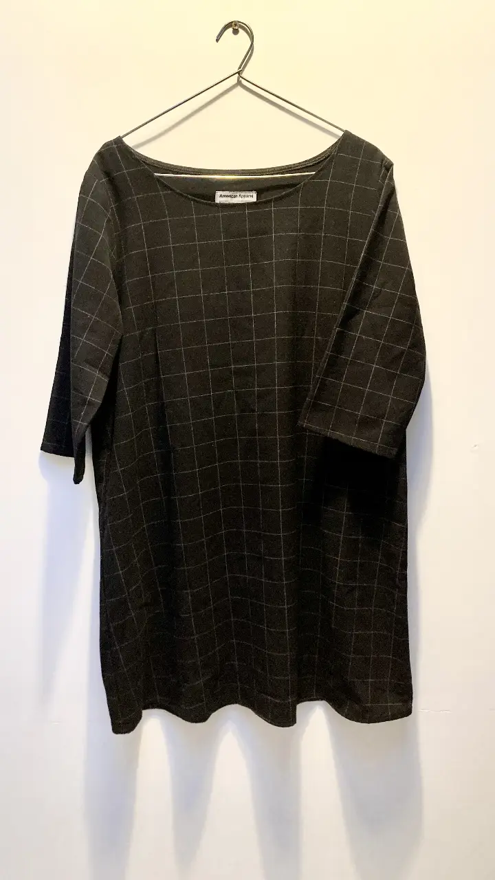 Vestido corto de la marca American Apparel, negro con estampado a cuadros (líneas blancas). Corte recto, mangas 3/4 y cuello redondo. Ideal para un look casual y moderno. Talle M/L. Tiene un calce muy cómodo, suelto y femenino.