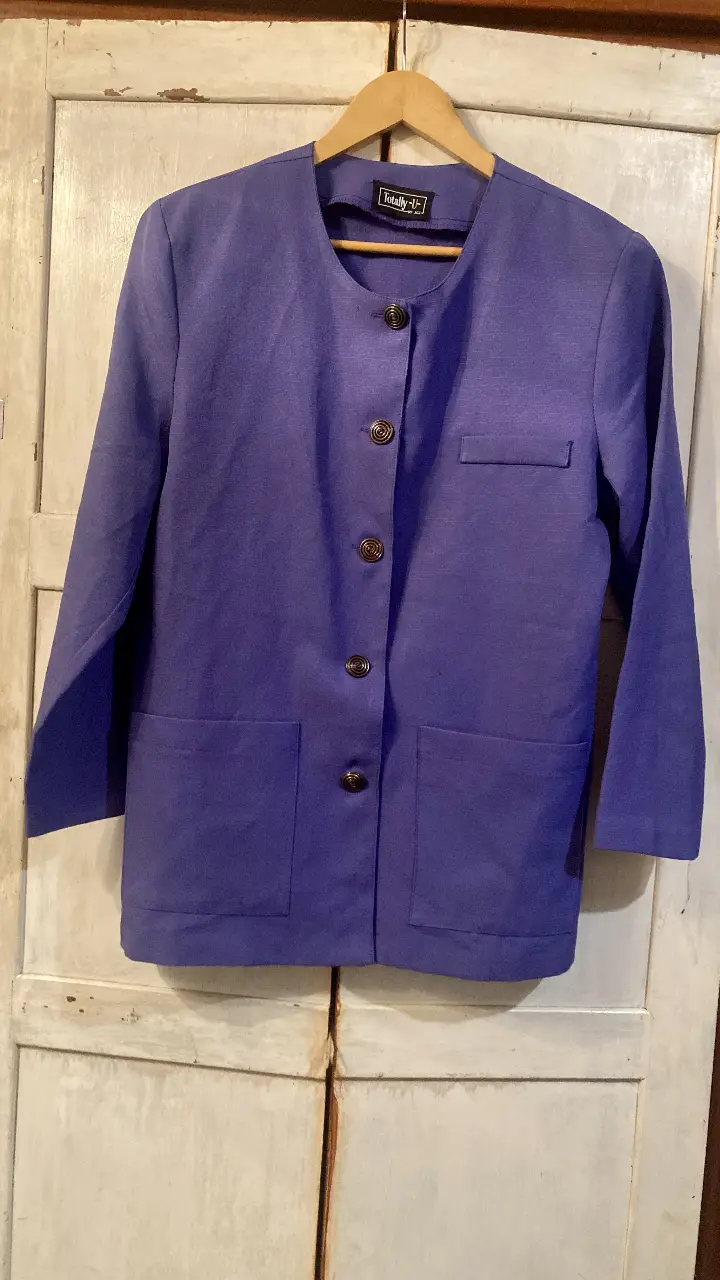 Blazer vintage de mujer color violeta, con botones, cuello redondo y bolsillos. La tela es lino. Talle M/L.