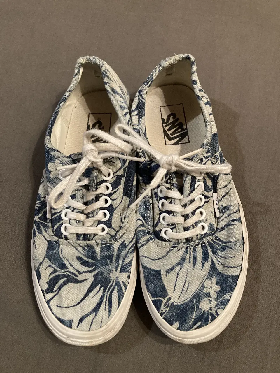 Zapatillas Vans Authentic con estampado floral en tonos azules y blancos. Diseño clásico con cordones blancos y suela de goma blanca. Talle 7 US para hombre y 8.5 US para mujer. Con muy poco uso como se puede ver en la suela y en la plantilla.