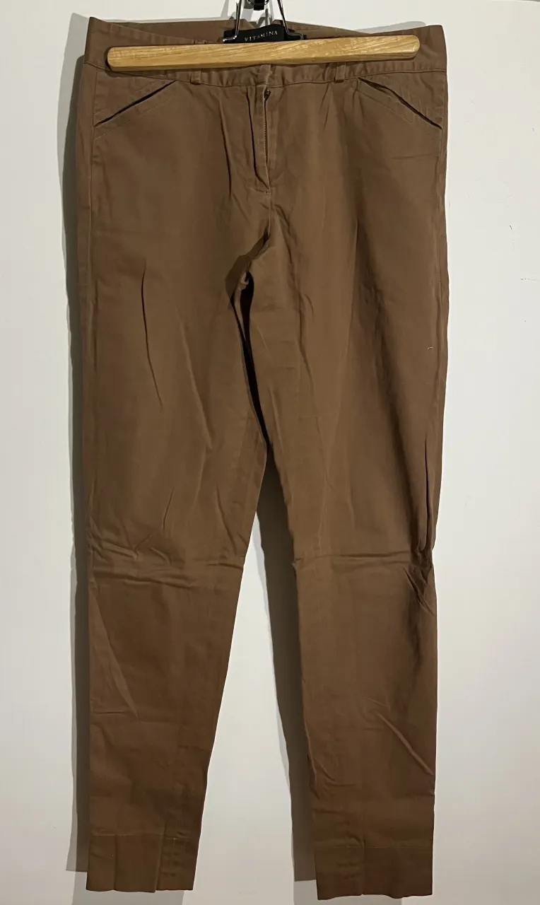 Pantalón Vitamina color marrón. Tiro medio, corte chupin y con detalles de bolsillos con tapa y botón en la parte trasera. Ajustable en la parte trasera. Ideal para un look casual o de trabajo. El ruedo tiene una parte descocida. Talle 1/38