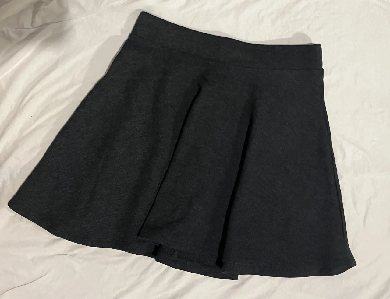 Pollera corta gris oscuro, ideal para un look casual y cómodo. Perfecta para combinar con remeras o buzos.