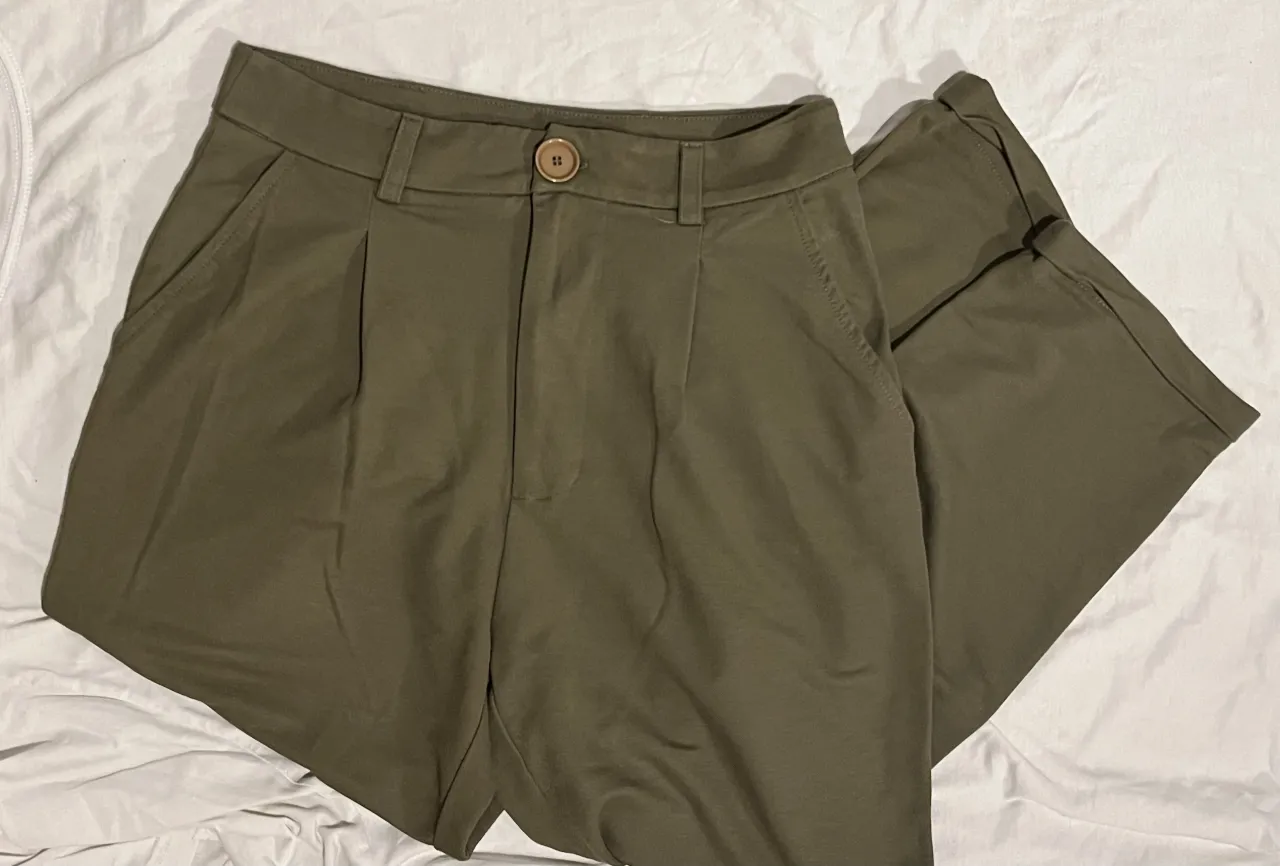 Pantalón color verde militar, con pinzas y bolsillos laterales. Un básico canchero y cómodo para tu día a día.