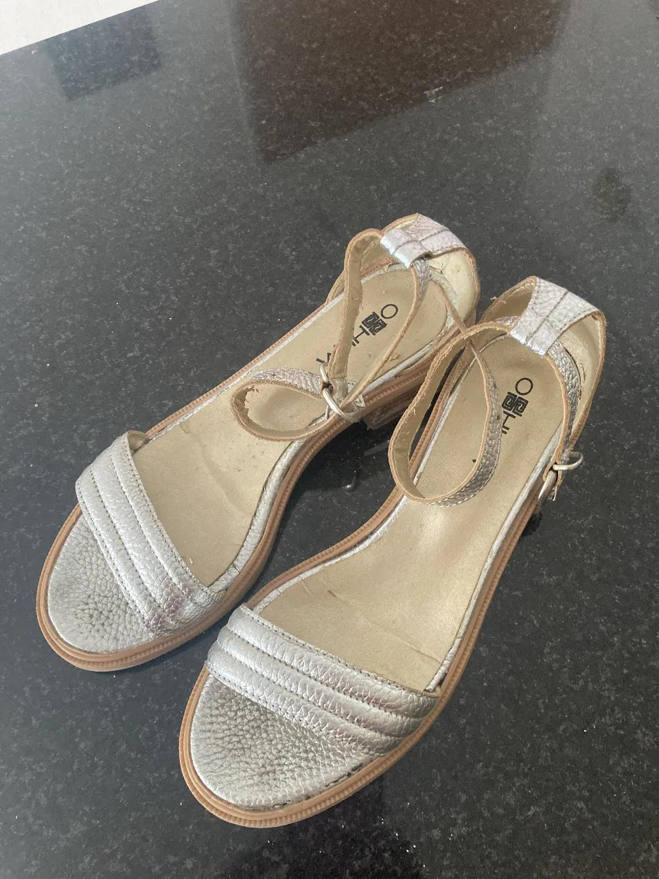 Sandalias plateadas de mujer, con pulsera en el tobillo y detalle de diseño en la capellada. Ideales para un look fresco y moderno. 36