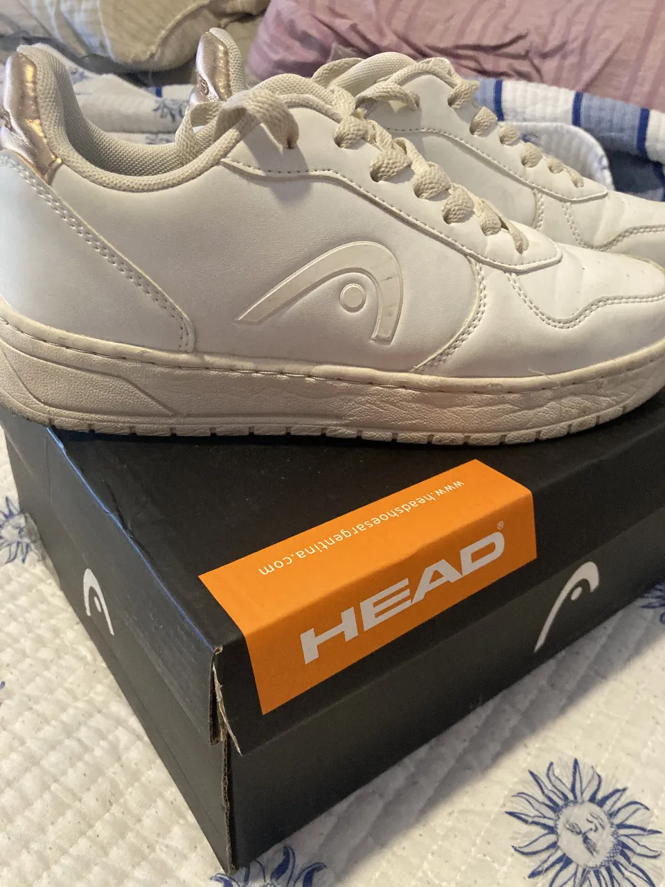 Zapatillas blancas de mujer, marca Head, con detalles dorados en el talón. Ideales para uso diario y combinar con cualquier outfit casual.