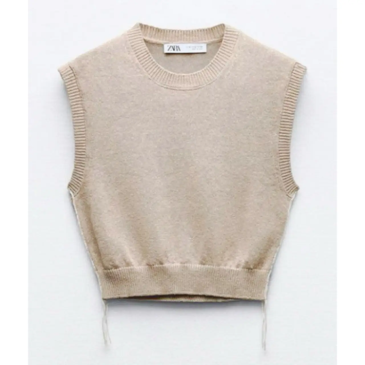 Chaleco tejido de punto, sin mangas, con cuello redondo y detalles de ajuste en los laterales. Ideal para un look casual y moderno.